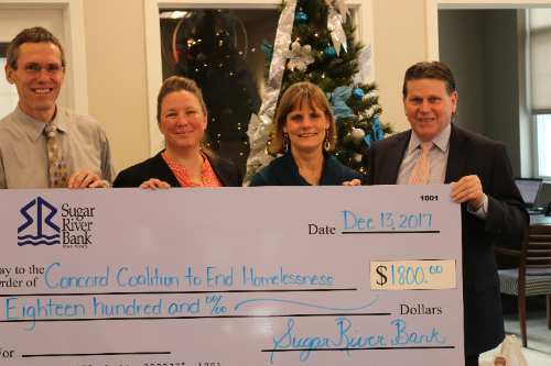 Sugar River Bank staff holding a check for $1,800.00 to go toward Concord Coalition to End Homelessness.
